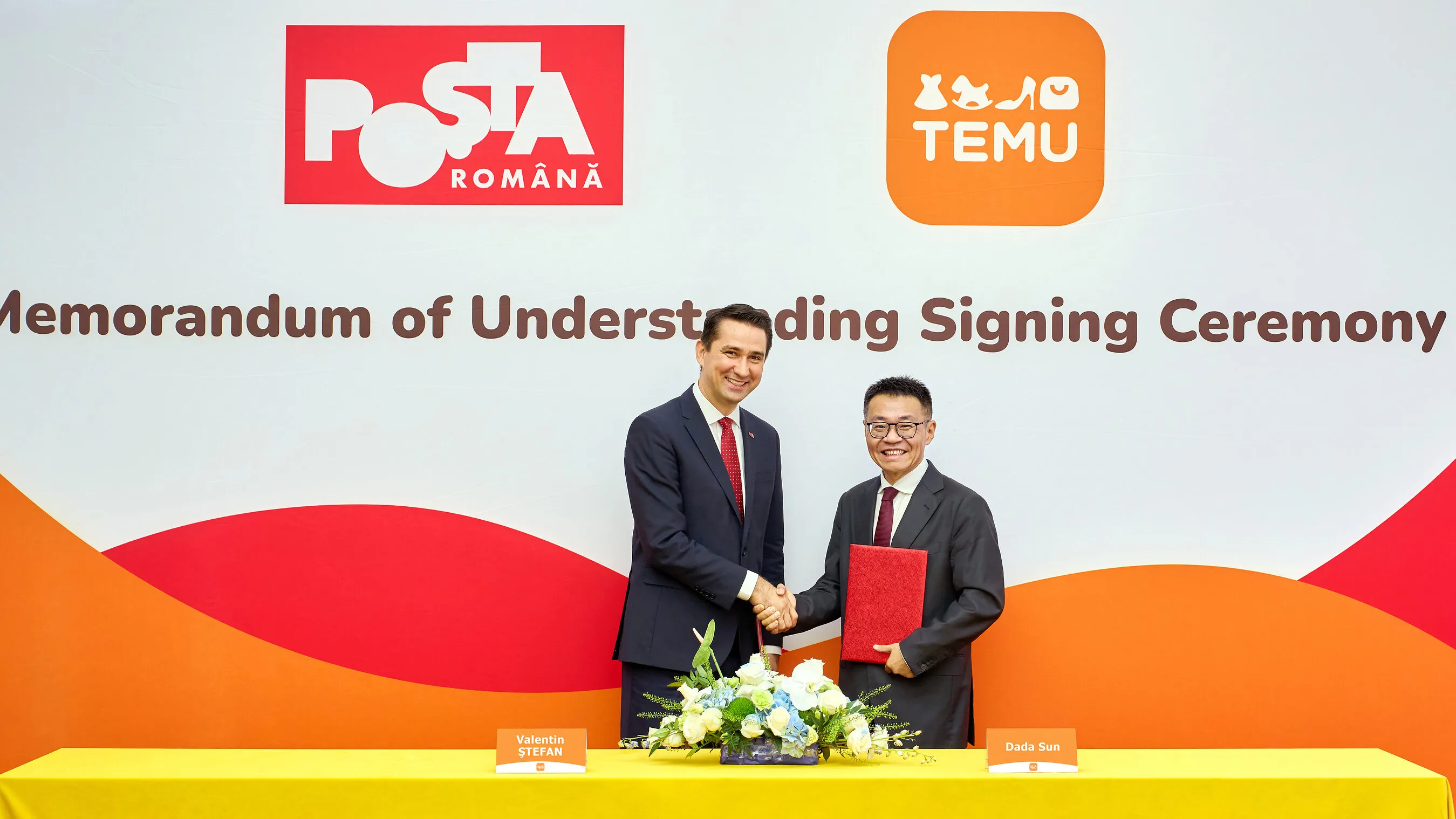Two men shake hands at a memorandum signing ceremony between Poșta Română and Temu.