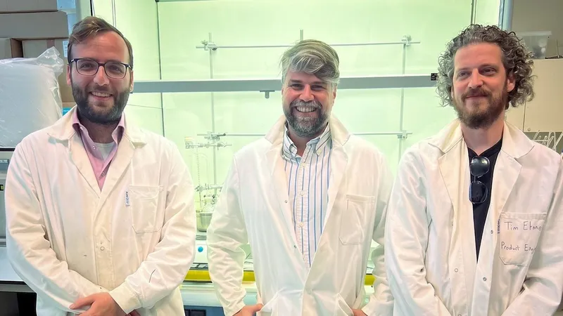 Three men in white lab coats standing in a laboratory.