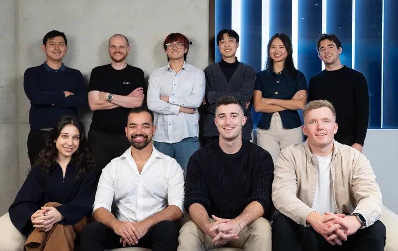 Ten people pose together indoors in two rows.