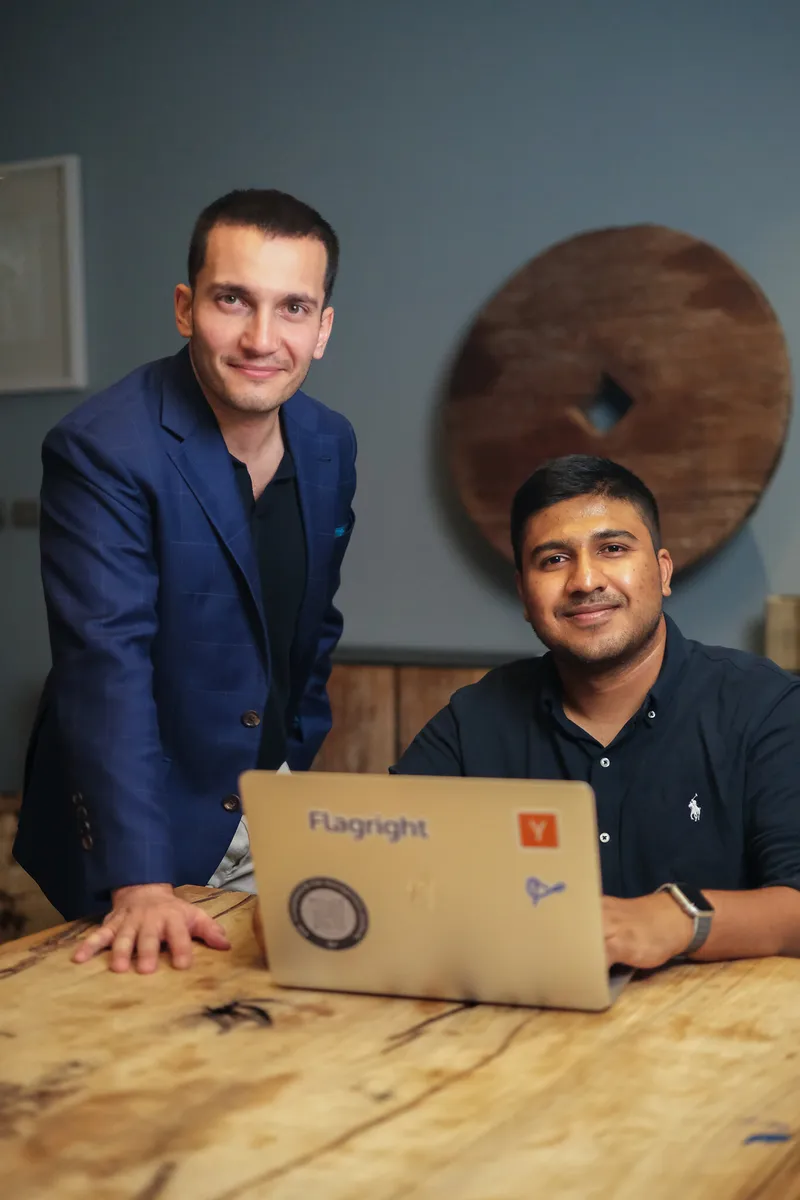 Baran Ozkan standing beside Madhu Nadig seated at a table with a laptop.