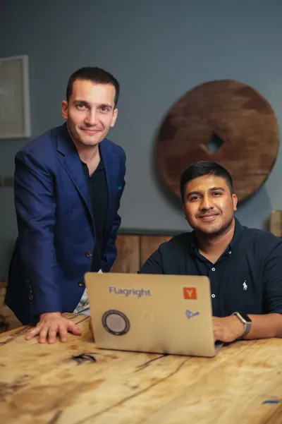 Baran Ozkan standing beside Madhu Nadig seated at a table with a laptop.