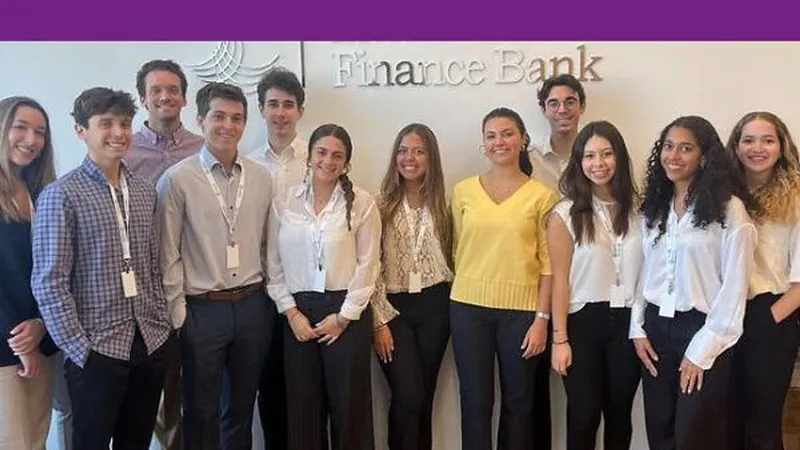 A group of young adults wearing lanyards stands in front of a Finance Bank sign.