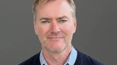 Greg Brogger in a head-and-shoulders portrait against a gray background
