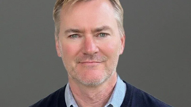 Greg Brogger in a head-and-shoulders portrait against a gray background