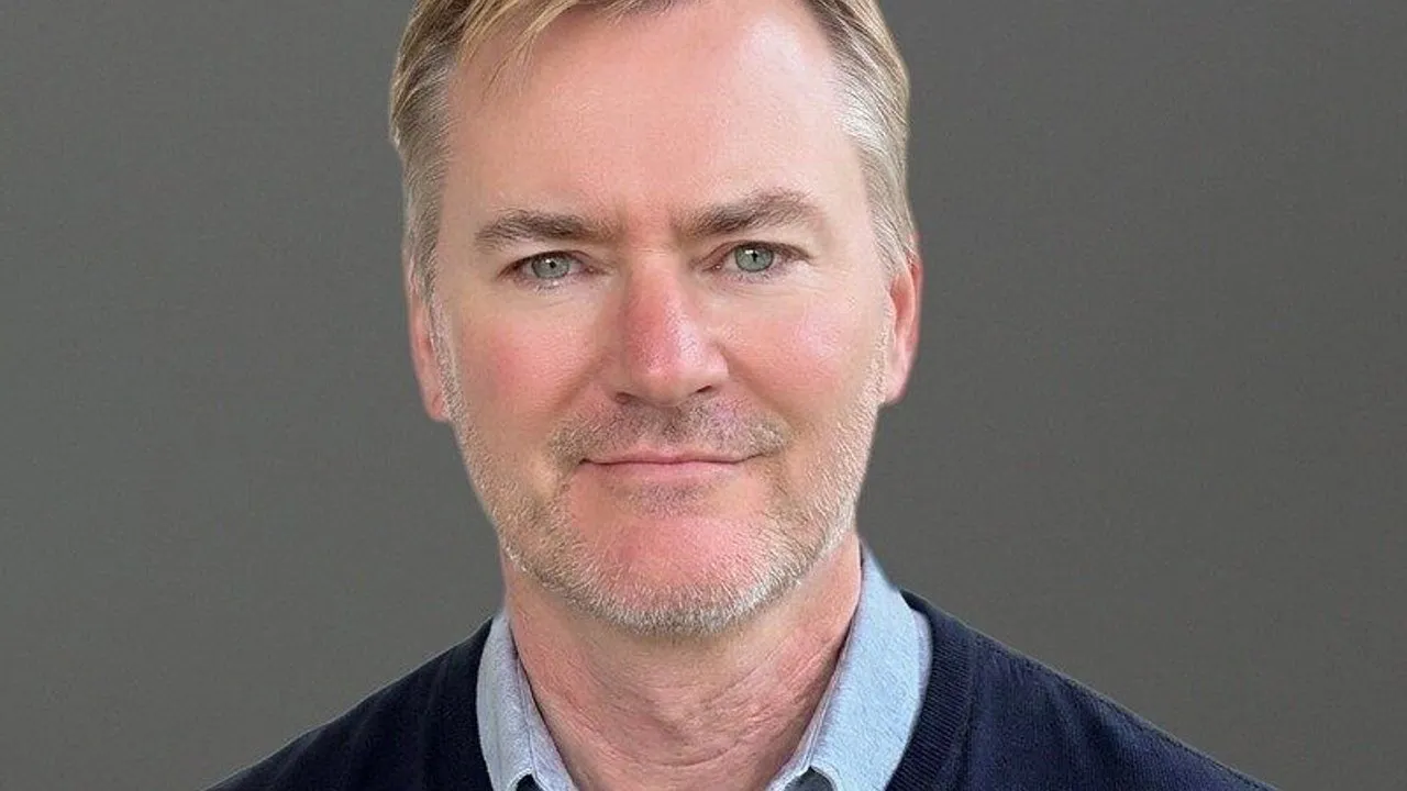 Greg Brogger in a head-and-shoulders portrait against a gray background