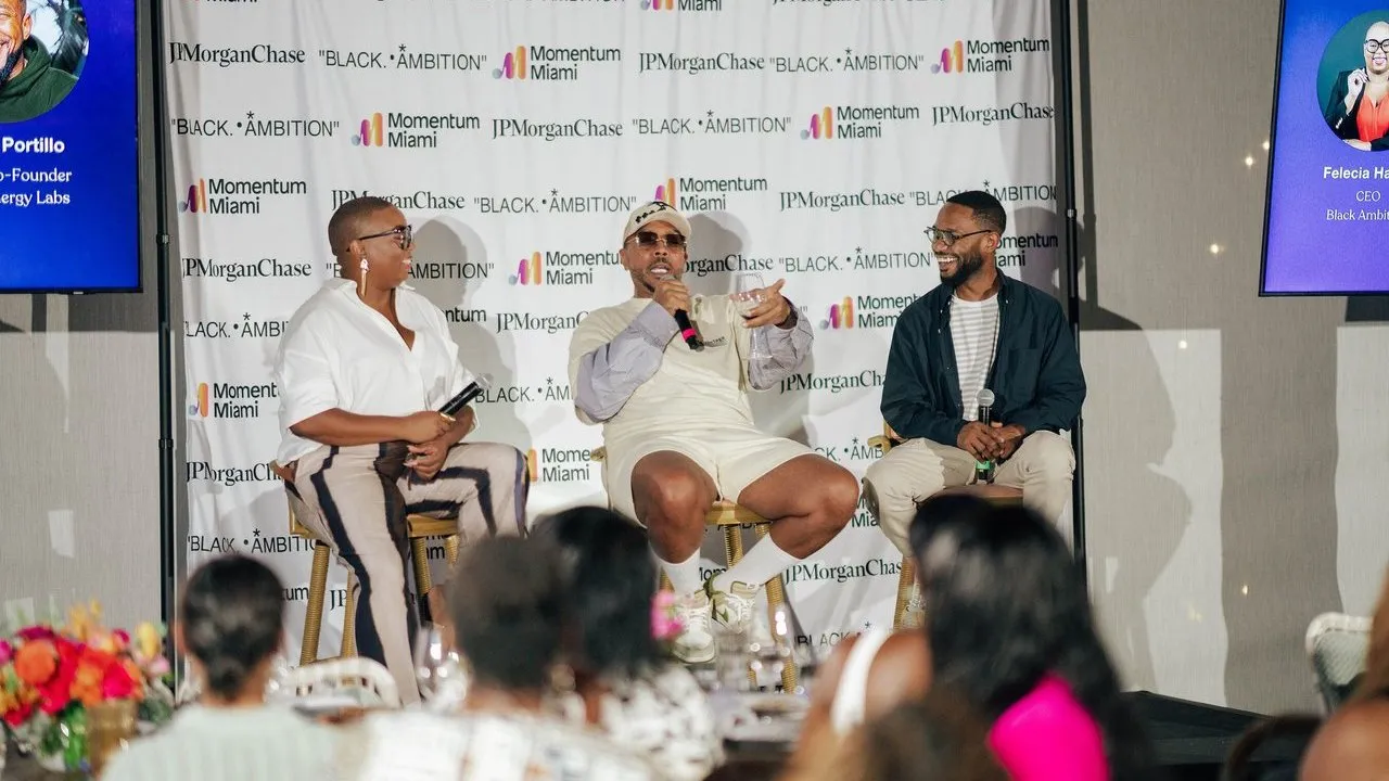 Three panelists with microphones speak before a Momentum Miami, JPMorgan Chase and Black Ambition backdrop.