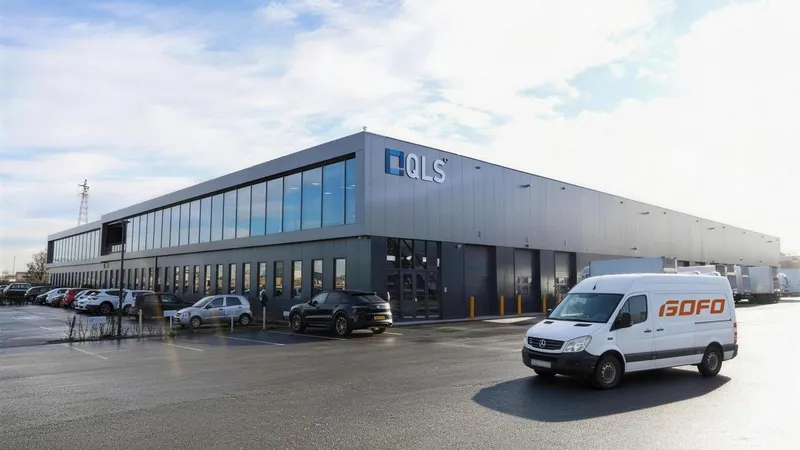 A white delivery van parked outside a modern industrial warehouse.
