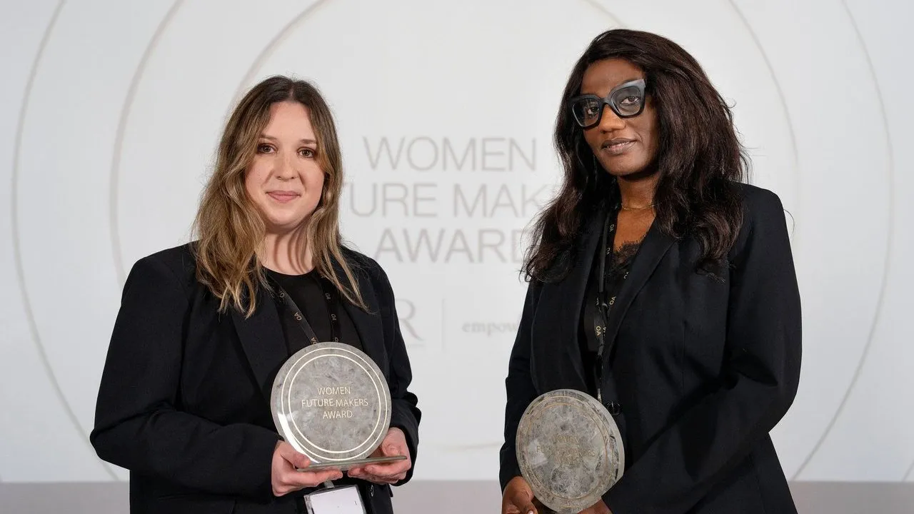 Two women holding Women Future Makers Award plaques onstage.