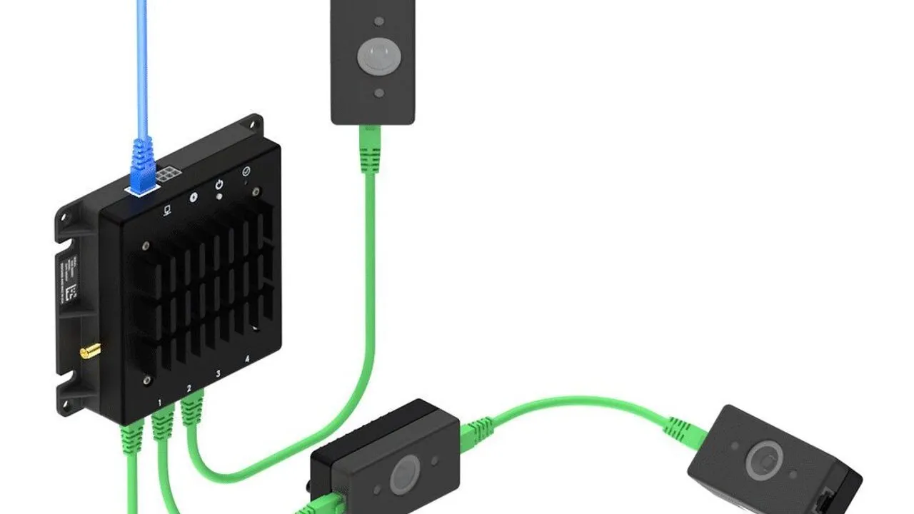 Black control unit connected by green cables to three compact cameras.