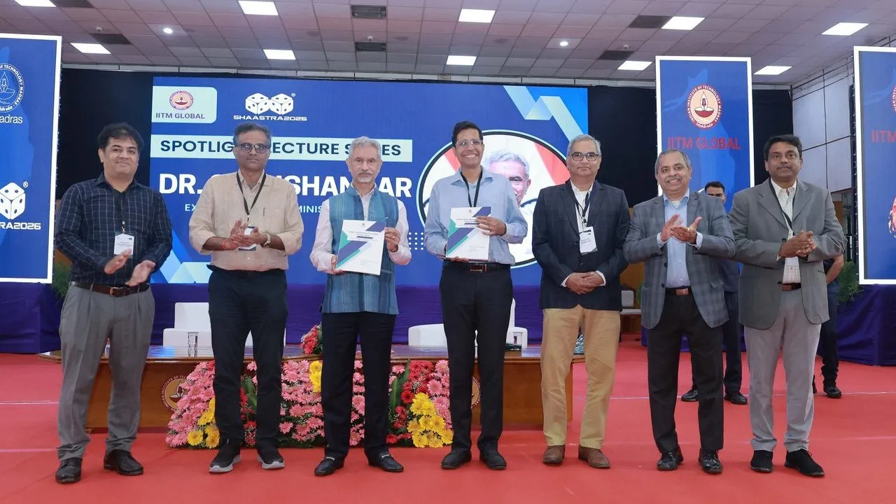 Seven men on a stage at IIT Madras holding a book during its release ceremony.
