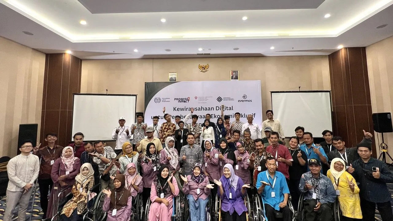 Group of attendees, including wheelchair users, posing at a digital accessibility event.