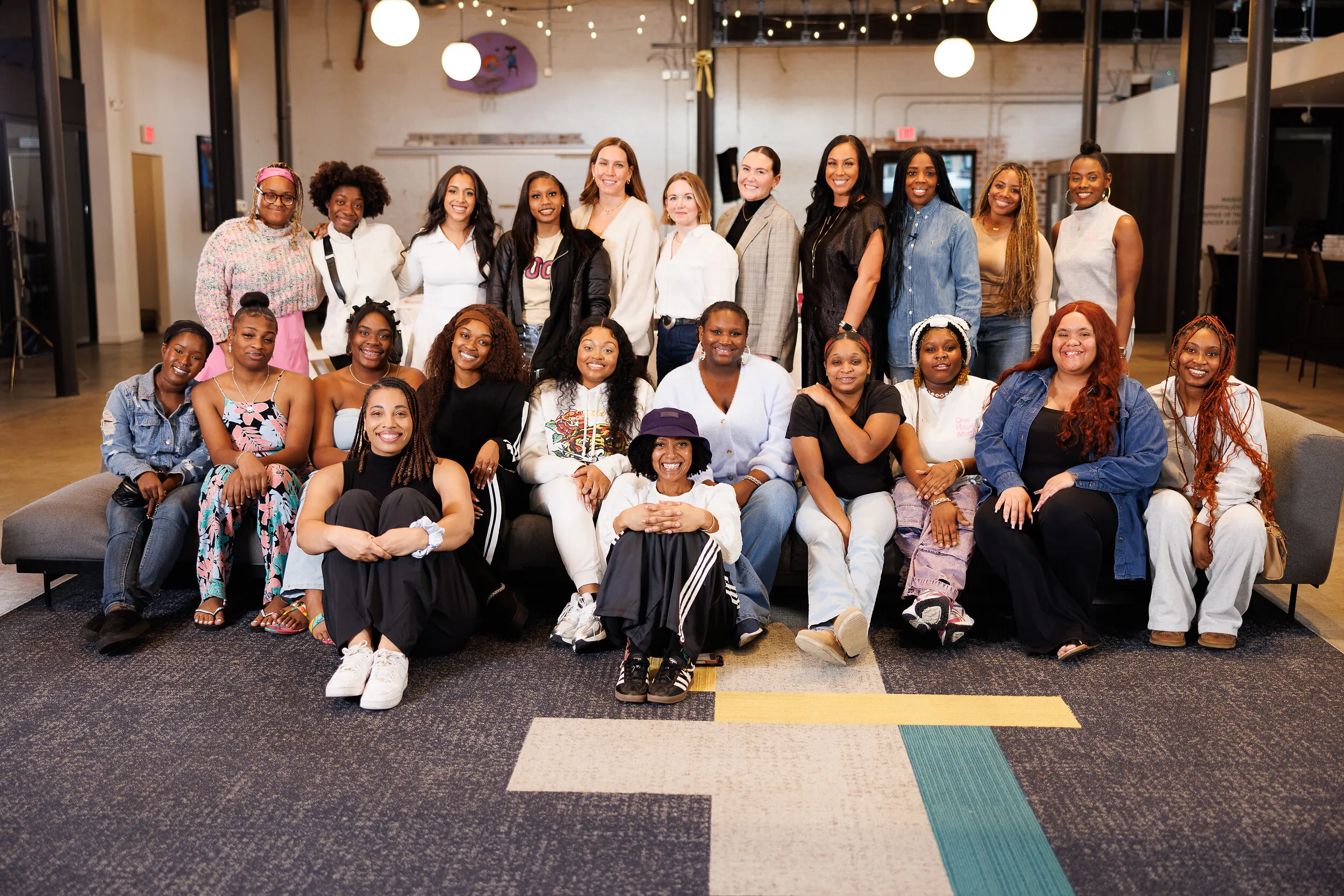 A group of women posing together in an office lounge.