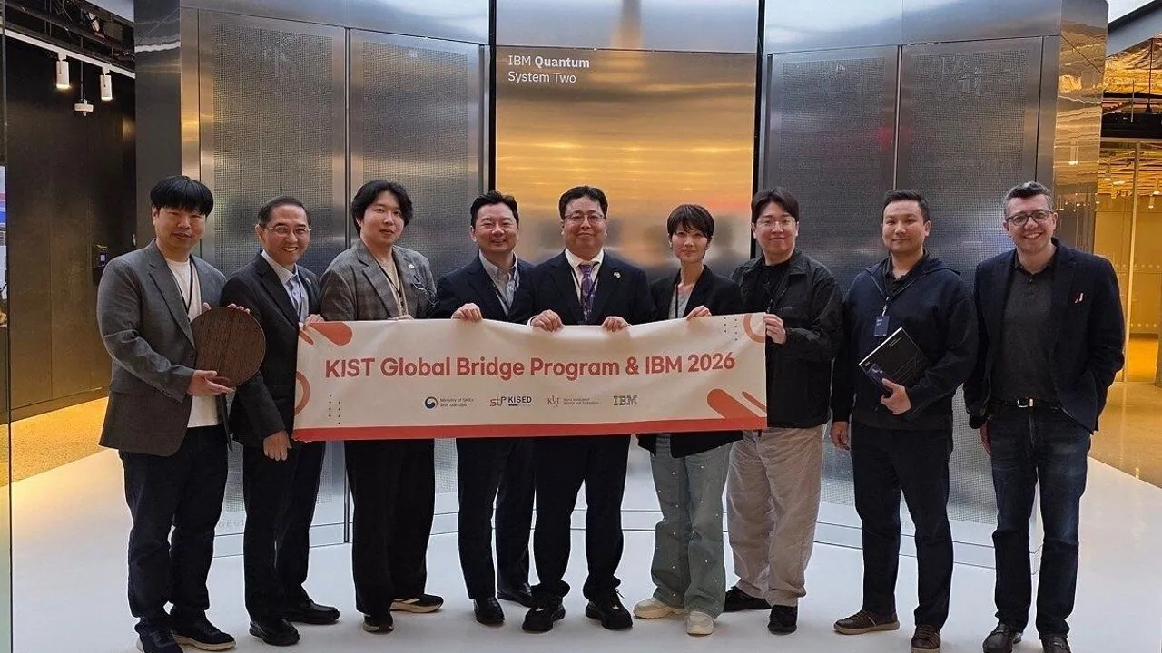 Nine people hold a KIST Global Bridge Program and IBM 2026 banner before IBM Quantum System Two.