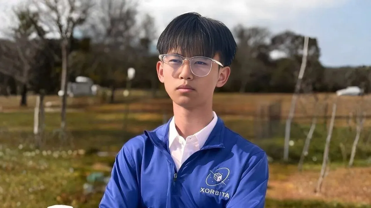 Minh Nguyen wearing glasses and a blue Xorbita jacket outdoors.