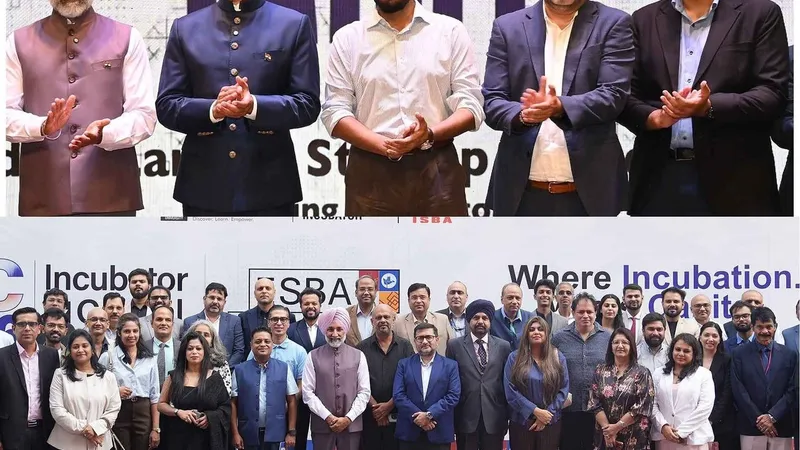Five people applauding above a large group posing at an incubator startup event.