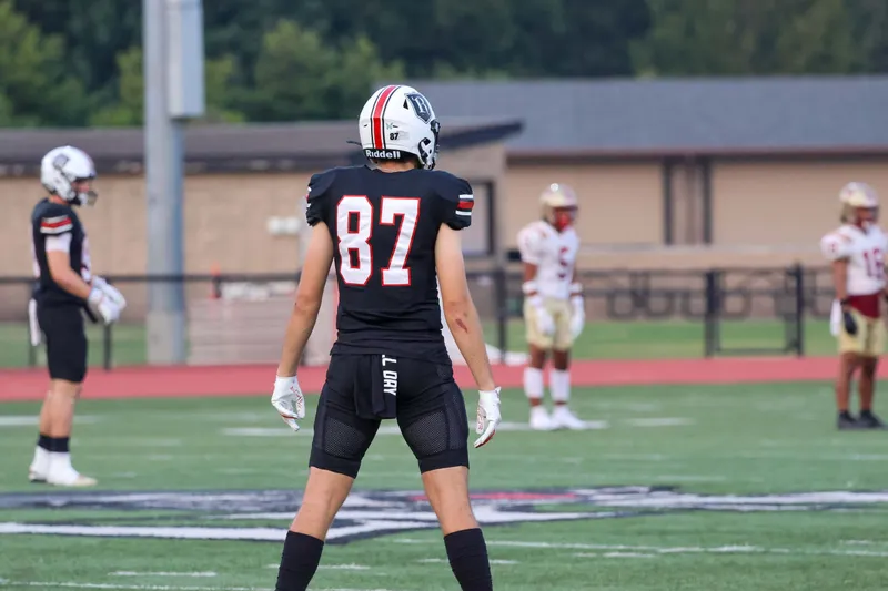 A football player wearing number 87 stands on the field during a game.