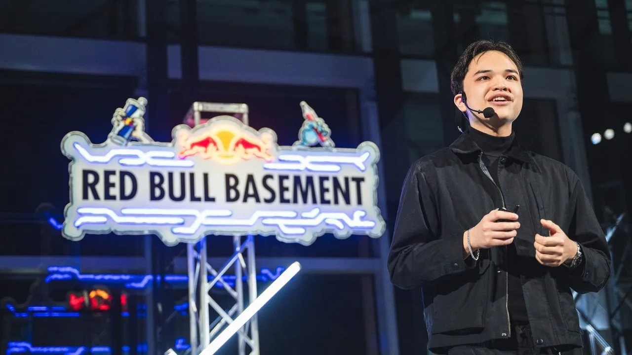 A Red Bull Basement participant wearing a headset speaks beside a Red Bull Basement sign.