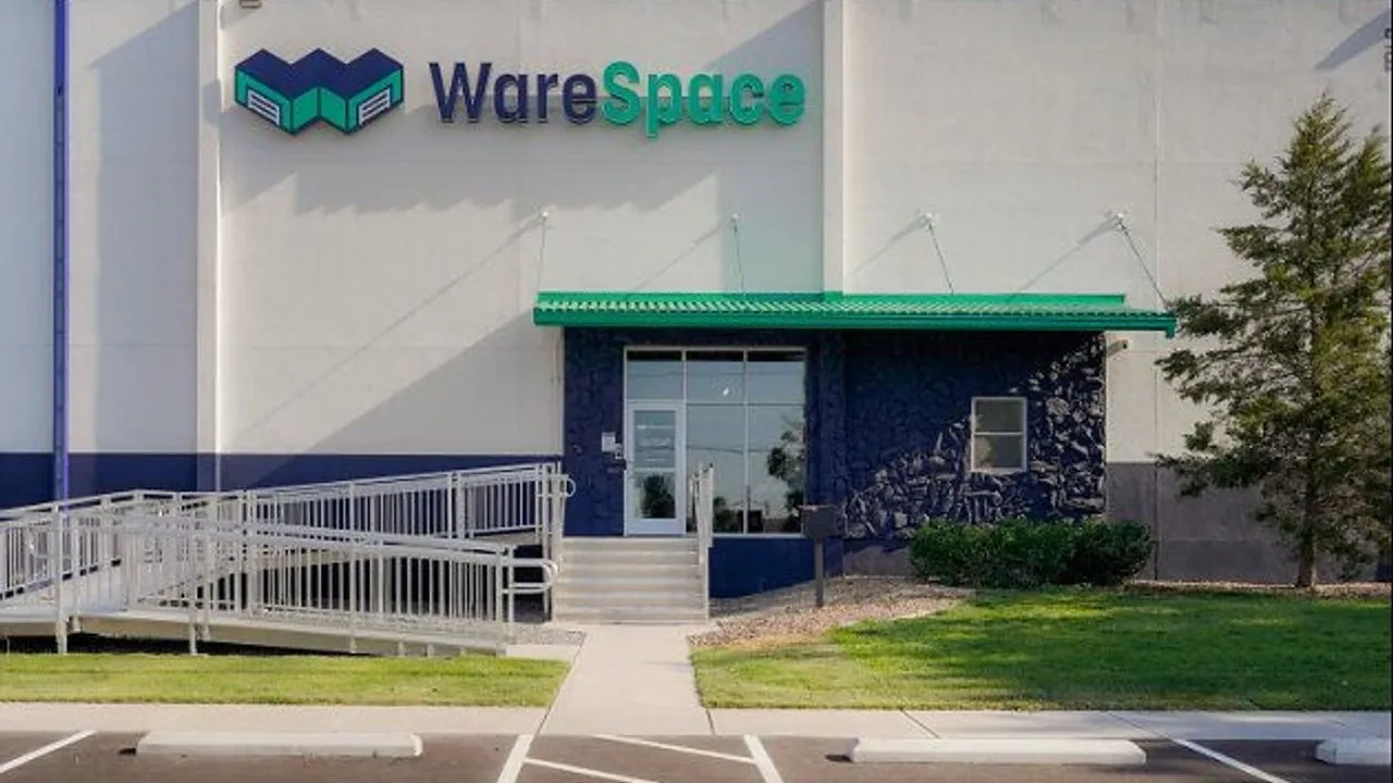 WareSpace building entrance with a green awning, wheelchair ramp and parking spaces.