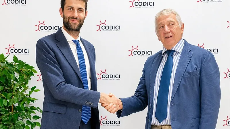Two men in blue suits shake hands before a CODICI logo backdrop.
