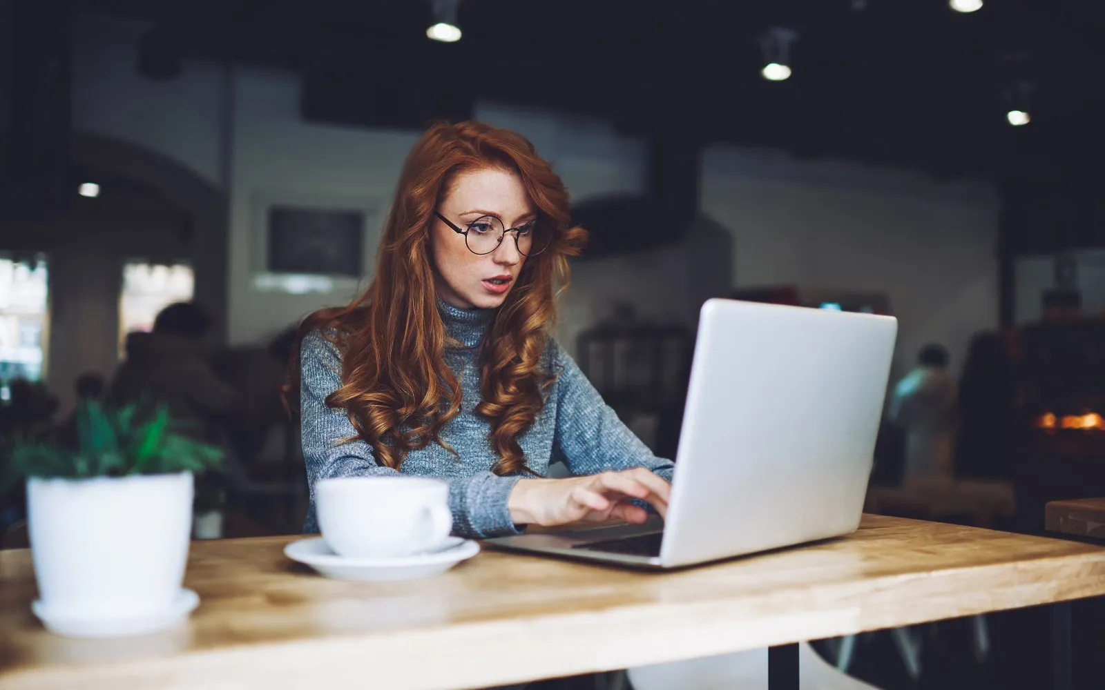 A woman working on a laptop in a café