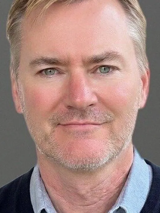 Greg Brogger in a head-and-shoulders portrait against a gray background